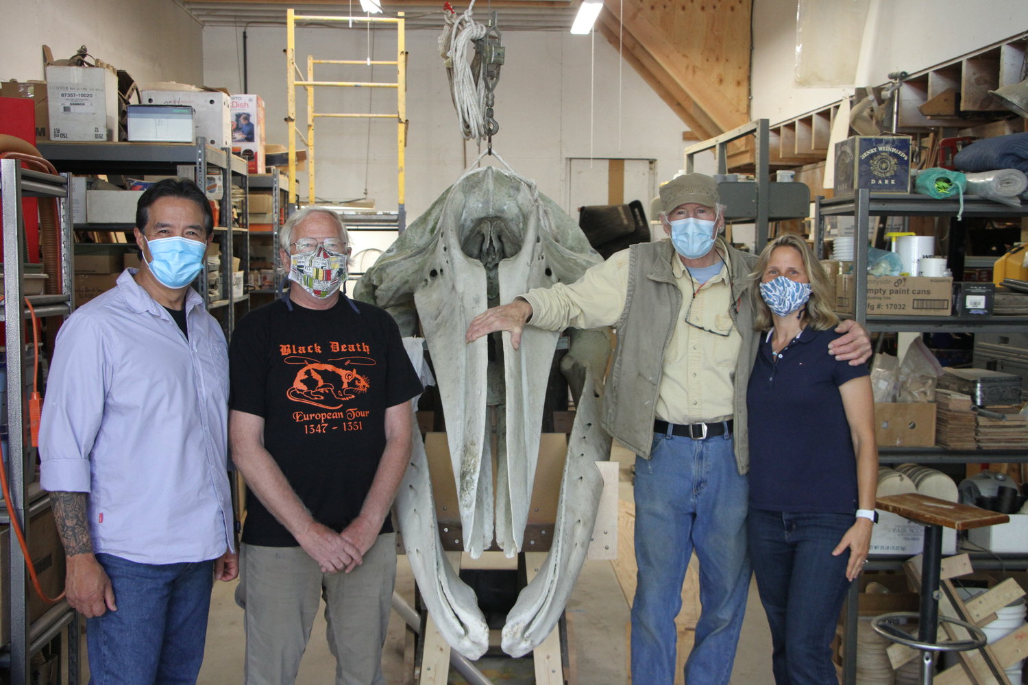 Mario Rivera, Ric Brenden, Les Schnick and Stefanie Worwag pose for a photo beside the skull of "Gunther" the gray whale.